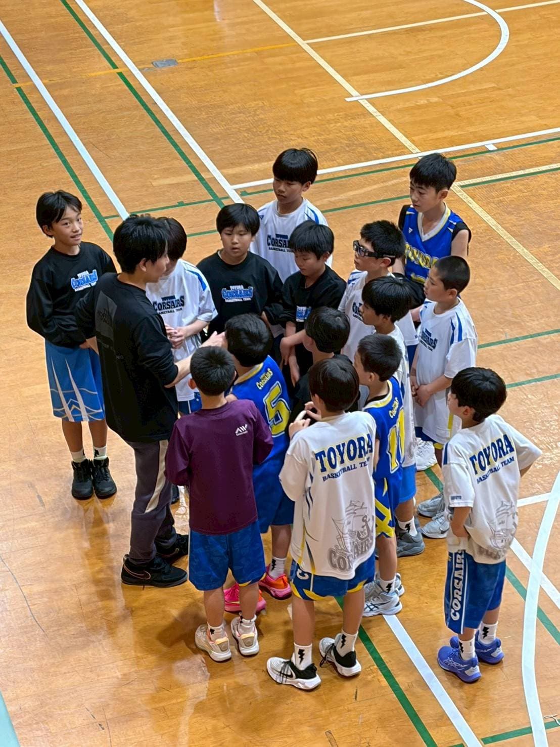 豊浦ミニバスの選手がコーチを囲んで話を聞く様子