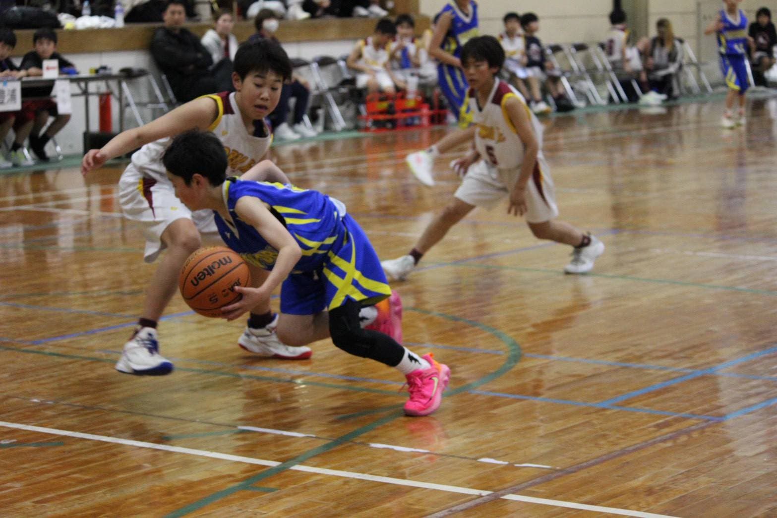 豊浦ミニバスの小学生選手が試合でパスを出す様子